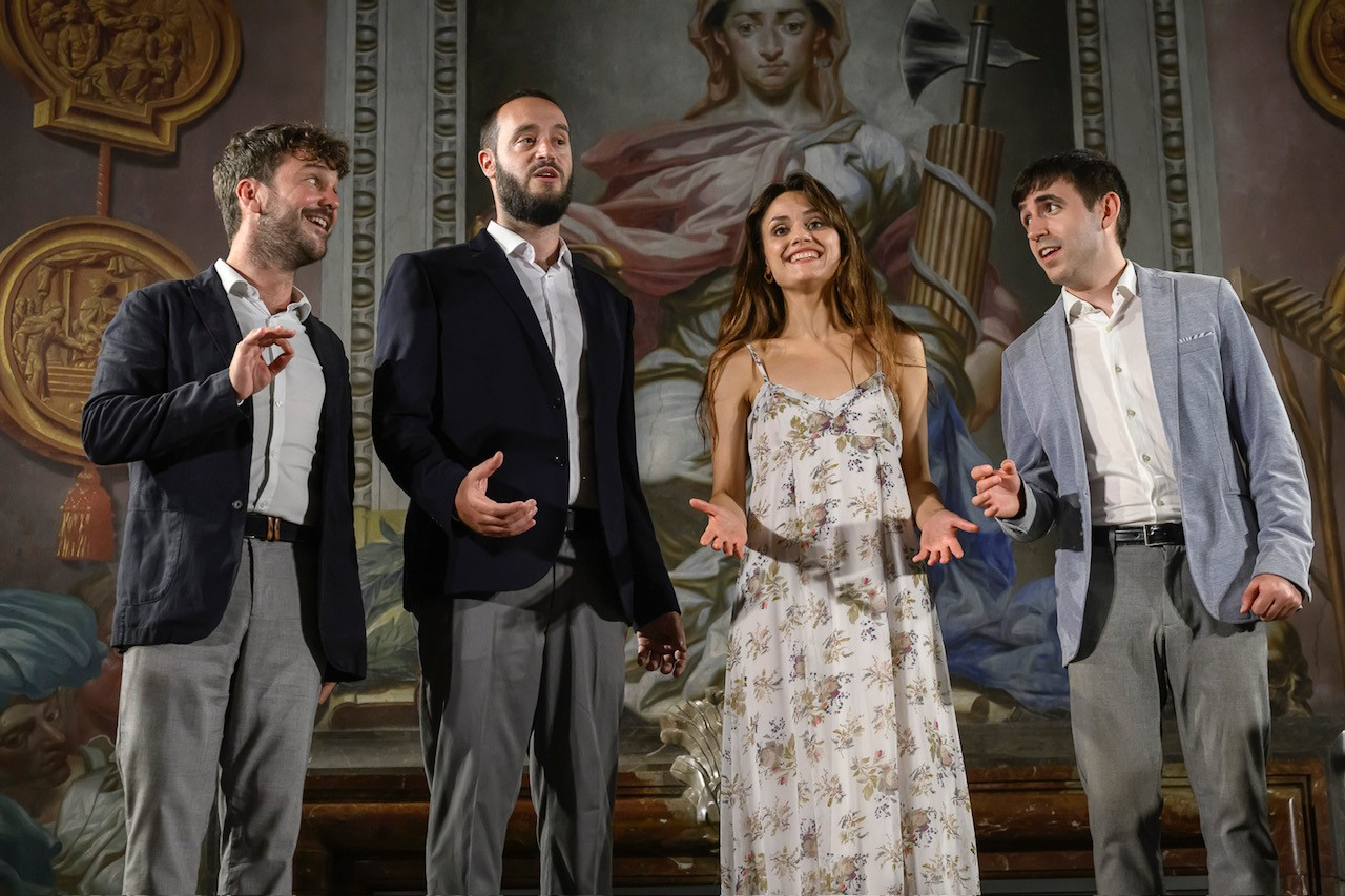 Cantoria, a Spanish quartet, stand and sing in front of a large painting