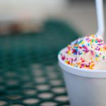Soft vanilla ice cream with rainbow sprinkles in a Styrofoam cup.
