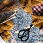 Cozy yarn, knitting needles, and scissors with twinkle lights